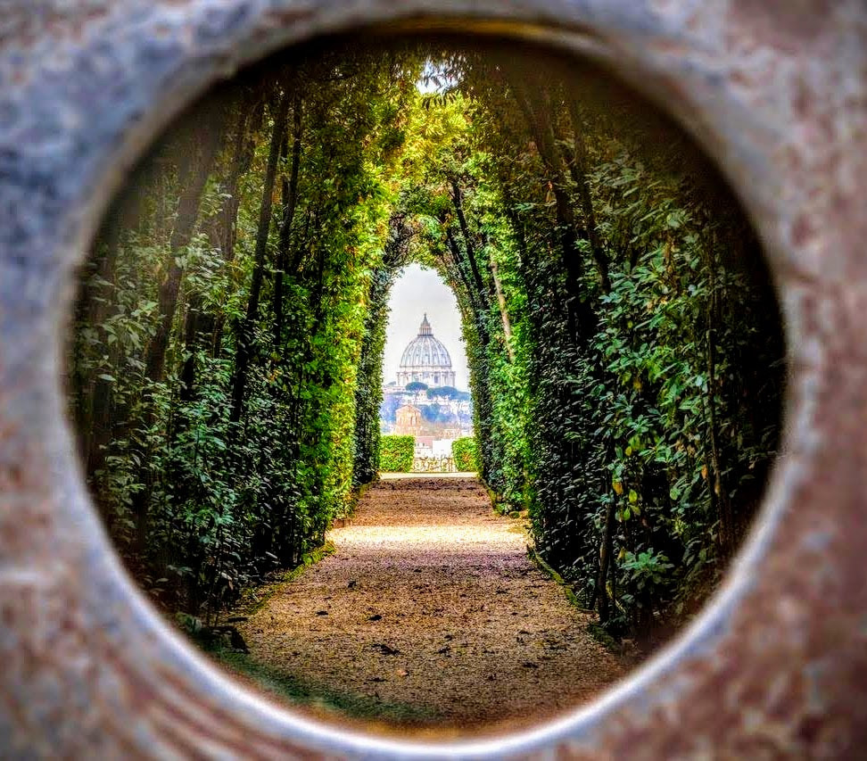 Enchanting view through the Aventine Keyhole, framing St. Peter's Basilica in Rome with precision and beauty.